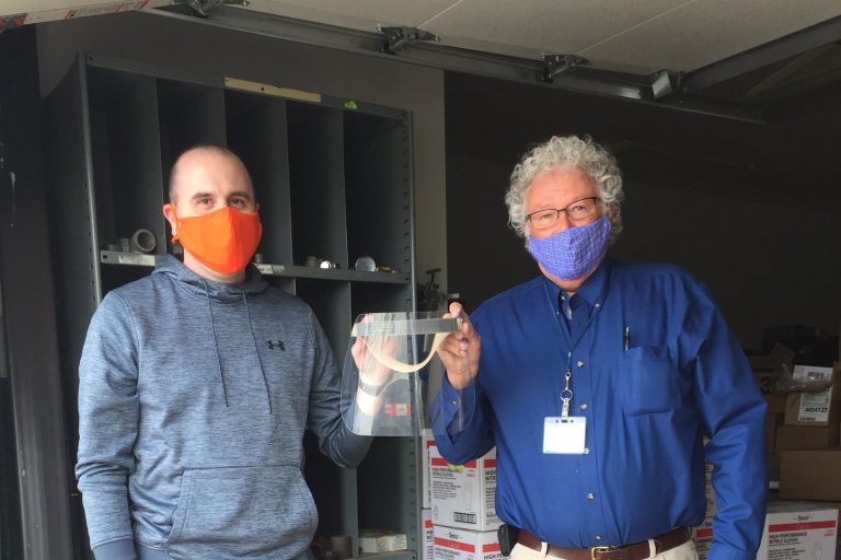 Scale-Tec employees holding face shields